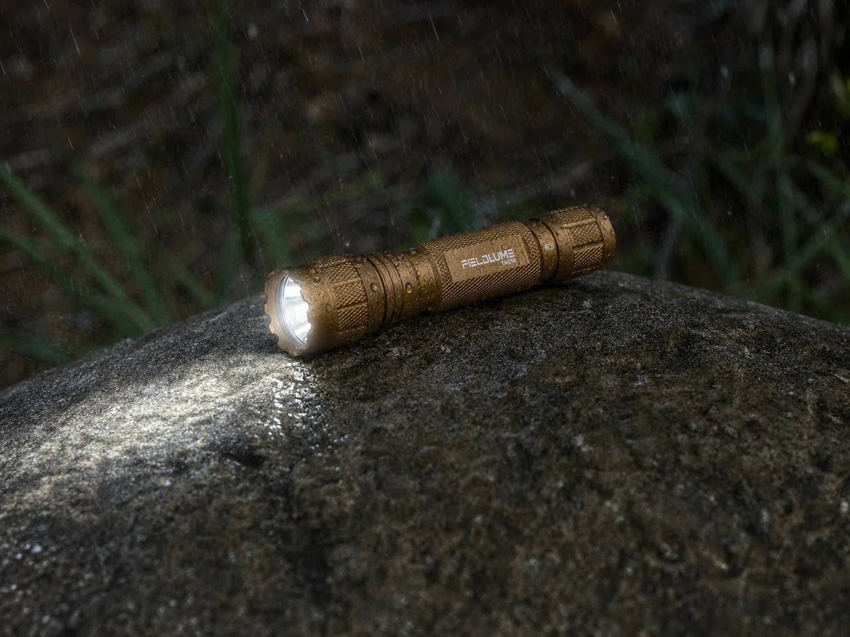 FIELDLUME TAC10 Tan tactical flashlight carried in an outdoor backpack pocket