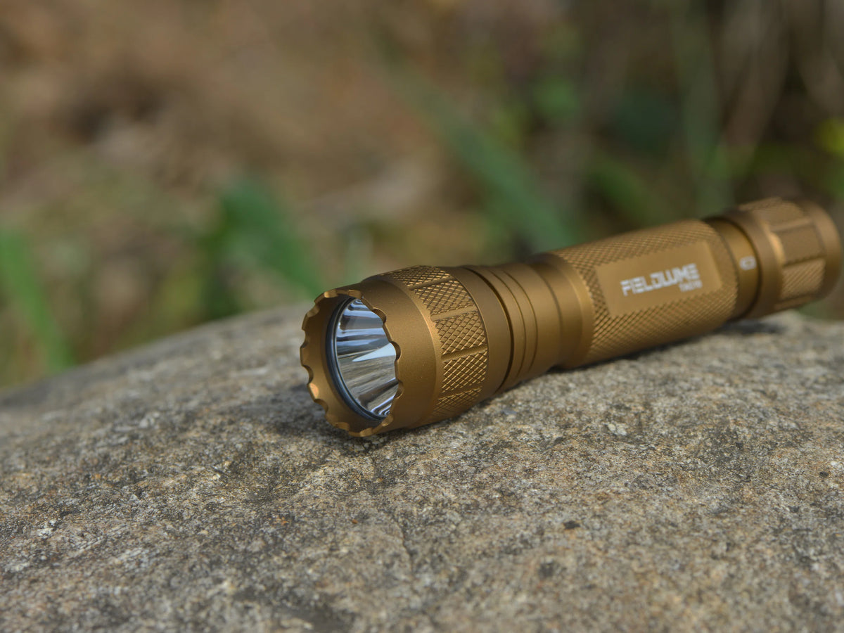 FIELDLUME TAC10 tan tactical EDC flashlight on rock