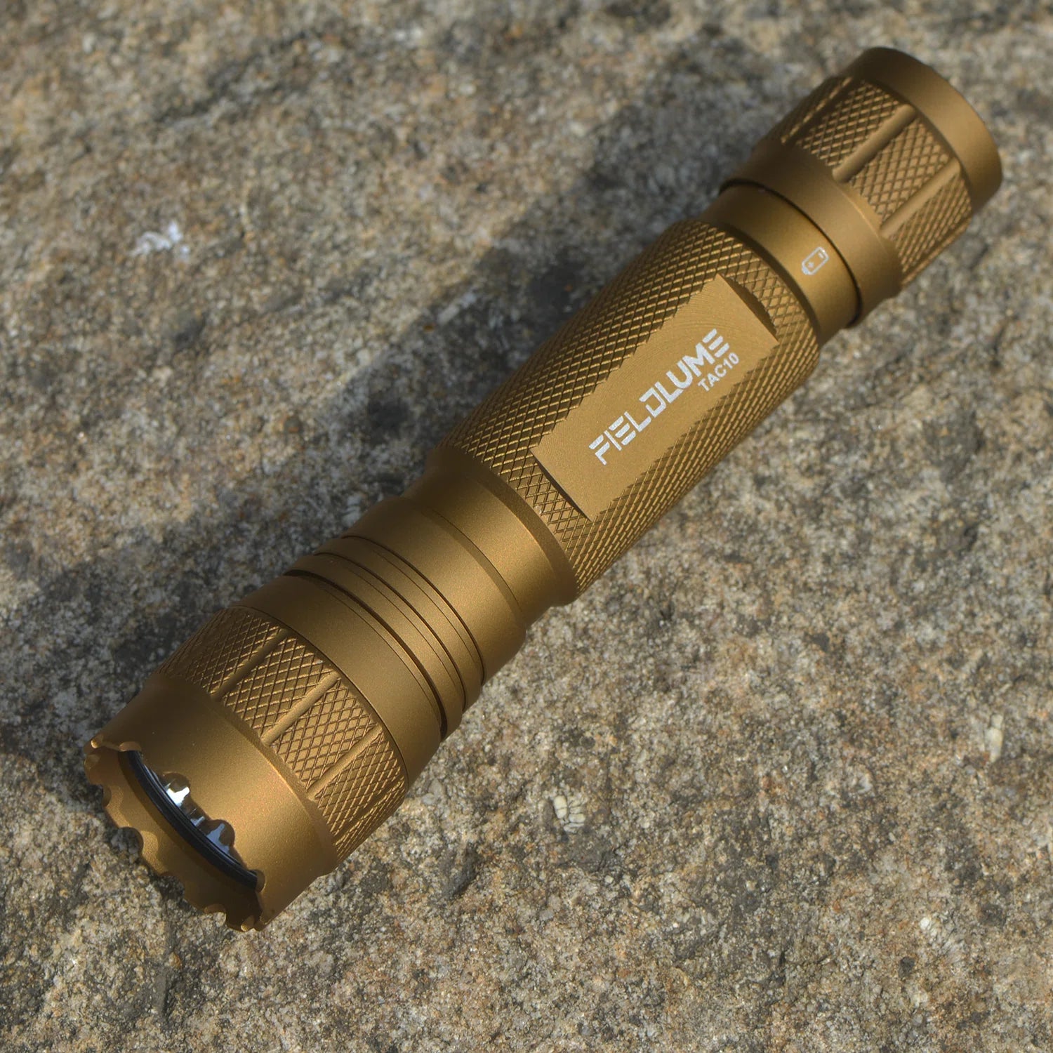 FIELDLUME TAC10 Tan tactical EDC flashlight on rock