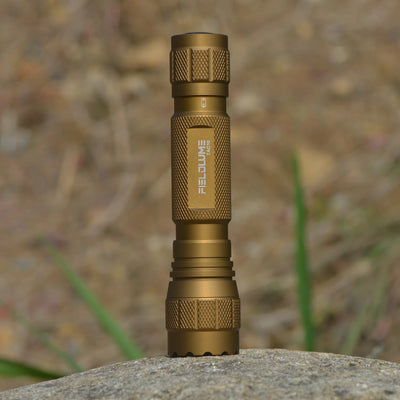 FIELDLUME TAC10 Tan flashlight standing outdoors